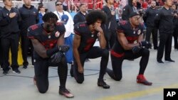 Jugadores de los San Francisco 49ers Eli Harold (58), mariscal de campo Colin Kaepernick (7) y Eric Reid (35) se arrodillan durante el himno national antes de un juego de la NFL, el 6 de octubre de 2016.