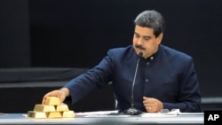 El presidente de Venezuela Nicolás Maduro toca una barra de oro mientras habla durante una reunión con sus ministros en el palacio de Miraflores en Caracas, Venezuela, el 22 de marzo del 2018. 