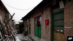 Quần áo treo bên ngoài lối vào một ngôi nhà gạch, được biết đến như là một "nhà tù đen" ở Bắc Kinh.