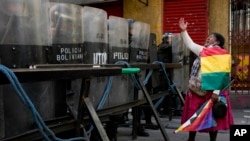 La policía bloquea el acceso al palacio presidencial mientras una seguidora del expresidente Evo Morales grita frente a ellos, en una protesta contra el gobierno en La Paz, Bolivia, el lunes 13 de enero de 2025. 