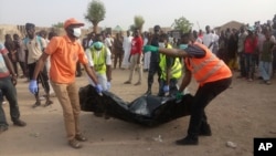 FILE - Rescue workers carry the body of a victim following a suicide attack in Maiduguri, Nigeria, April 27, 2018. Nigeria's government now acknowledges, Feb. 12, 2019, an extremist resurgence estimated to have more than 3,000 fighters. 