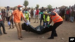 FILE - Rescue workers carry the body of a victim following a suicide attack in Maiduguri, Nigeria, April 27, 2018. Nigeria's government now acknowledges, Feb. 12, 2019, an extremist resurgence estimated to have more than 3,000 fighters. 