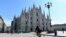 A biker rides past the Duomo di Milano on Piazza del Duomo in central Milan on March 8, 2020.