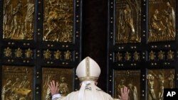 Le pape pousse la "porte sainte" de la basilique Saint-Pierre, le 8 décembre 2015. (AP Photo/Gregorio Borgia)