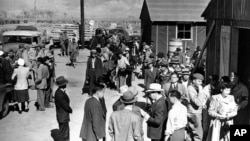 FILE - The first arrivals at the Japanese evacuee community established in Owens Valley in Manzanar, Calif., part of a vanguard of workers from Los Angeles, March 23, 1942. Roughly 120,000 Japanese immigrants and Japanese-Americans were sent to camps that dotted the West because the government claimed they might plot against the U.S. 