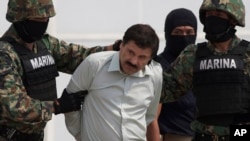 In this Feb. 22, 2014 file photo, Joaquin "El Chapo" Guzman is escorted to a helicopter in handcuffs by Mexican navy marines at a navy hanger in Mexico City, Mexico. Mexican President Enrique Pena Nieto posted on his Twitter account, Friday, Jan. 8, 2016, that drug lord Joaquin 'Chapo' Guzman has been recaptured. (AP Photo/Eduardo Verdugo, File)