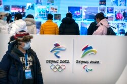 Seorang jurnalis mengenakan topeng di pusat pengunjung di tempat Olimpiade Musim Dingin di Yanqing di pinggiran Beijing, Jumat, 5 Februari 2021. (Foto: AP)