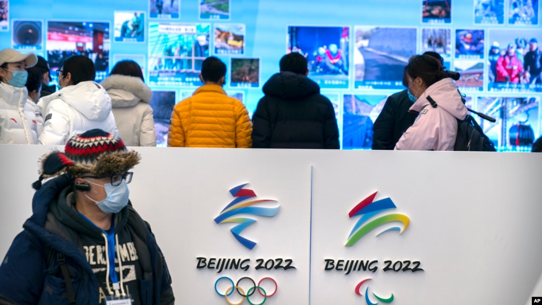 Seorang jurnalis mengenakan masker saat melihat pameran di tempat Olimpiade Musim Dingin di Yanqing di pinggiran Beijing, Jumat, 5 Februari 2021. (AP Photo/Mark Schiefelbein)