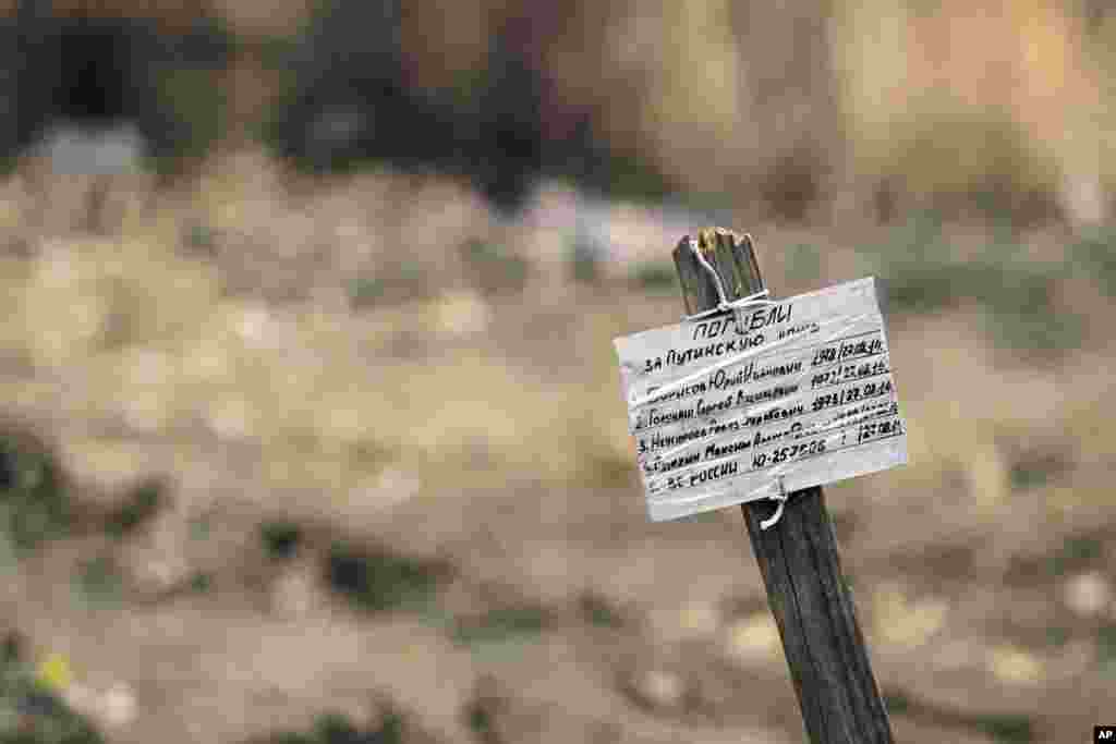 A marker with the epitaph: "They died for Putin's lies" is seen at a mass grave in the village of Nyzhnya Krynka, eastern Ukraine, Sept. 23, 2014.