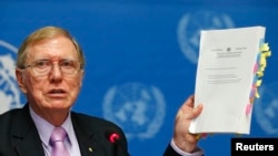 FILE - Michael Kirby, Chairperson of the Commission of Inquiry on Human Rights in North Korea holds a copy of his report during a news conference at the United Nations in Geneva February 17, 2014. 