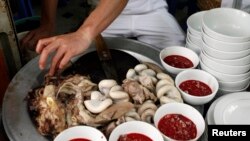 A raw blood dish is displayed with cooked entrails at a restaurant in Hanoi April 28, 2009. Frozen pudding from fresh duck or pig blood is a popular dish in the Southeast Asian country although duck blood is less consumed following bird flu outbreaks that have killed at least 55 Vietnamese since late 2003. 