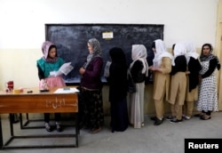 Afghan women arrive at a voter registration center to register for the upcoming parliamentary and district council elections in Kabul, Afghanistan, April 23, 2018.