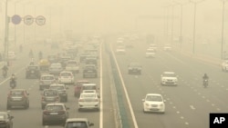 Traffic moves on a road enveloped by toxic smog in New Delhi, India, on Nov. 3, 2023.