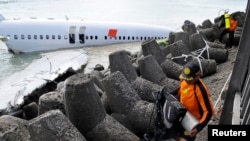 Para anggota tim penyelamat dekat bangkai pesawat Lion Air dekat landasan Bandar Udara Ngurah Rai, Bali, 15 April 2013. 