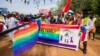 FILE - People holding rainbow flags take part in the Gay Pride parade in Entebbe, Aug. 8, 2015. 