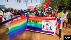 FILE - People holding rainbow flags take part in a Gay Pride parade in Entebbe, Uganda, Aug. 8, 2015. Critics of the new NGO bill say organizations such as those promoting LGBT rights will likely be among those stifled.
