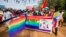 FILE - People holding rainbow flags take part in the Gay Pride parade in Entebbe, Aug. 8, 2015. 