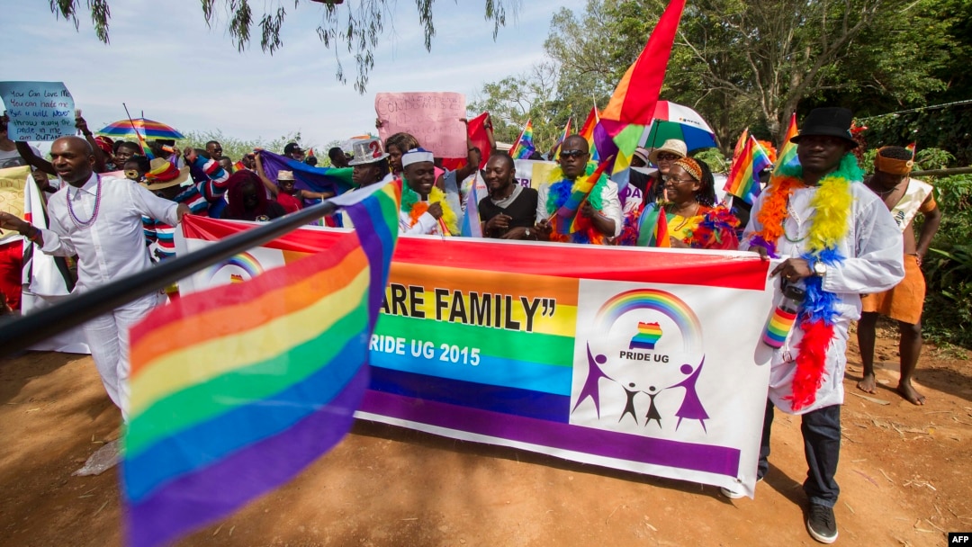 FILE - People holding rainbow flags take part in the Gay Pride parade in Entebbe, Uganda, Aug. 8, 2015. 