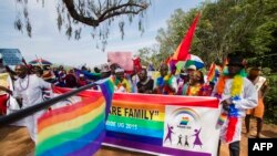FILE - People holding rainbow flags take part in the Gay Pride parade in Entebbe, Aug. 8, 2015. 