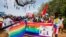 FILE - People holding rainbow flags take part in the Gay Pride parade in Entebbe, Aug. 8, 2015. 