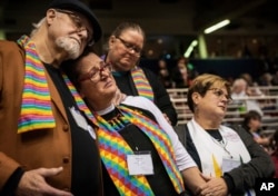 FILE - Ed Rowe, left, Rebecca Wilson, Robin Hager and Jill Zundel react to the defeat of a proposal that would allow LGBT clergy and same-sex marriage within the United Methodist Church at the denomination's 2019 Special Session of the General Conference in St. Louis, Mo., Feb. 26, 2019.