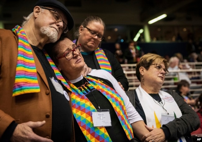 FILE - Ed Rowe, left, Rebecca Wilson, Robin Hager and Jill Zundel react to the defeat of a proposal that would allow LGBT clergy and same-sex marriage within the United Methodist Church at the denomination's 2019 Special Session of the General Conference in St. Louis, Mo., Feb. 26, 2019.