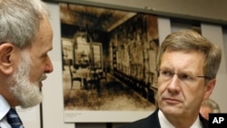German President Christian Wulff, right, listens to the house director Norbert Kampe, left, during a 70 years 'Wannsee Conference' remembrance day at the house of the Wannsee conference in Berlin, Jan. 20, 2012.