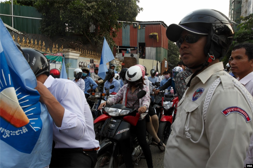 Á security police safeguards a self-claim university students group led by Srey Chamroeun. Some 70 students protest in front the house of CNRP&#39;s acting president Kem Sokha in Phnom Penh. Based on leaked phone records conversation, the group accused Kem Sokha of having immorally relations with a hairdresser Khom Chandarati. ( Leng Len/VOA Khmer) &nbsp;