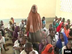 While waiting for their teachers to return, Cameroonian students are relying on lessons taught by humanitarian workers and military personnel. Here, a young girl answers her substitute teacher's question in Fotokol, May 11, 2018. (M. Kindzeka/VOA)