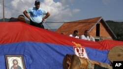 An icon and Serbian flag cover a barricade on the road near the village of Zupce, northern Kosovo, Monday, Aug. 1, 2011