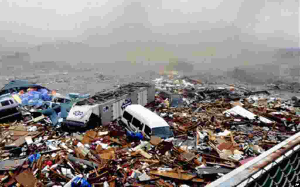 Cars and other debris swept away by tsunami tidal waves are seen in Kesennuma in Miyagi Prefecture, northern Japan, after strong earthquakes hit the area, March 11, 2011 - (AP)