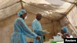 Health workers take blood samples for Ebola virus testing at a screening tent in the local government hospital in Kenema, Sierra Leone, June 30, 2014.