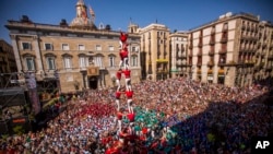 Anggota "Castellers" Barcelona, kelompok akar rumput yang memimpin gerakan kemerdekaan Catalonia membentuk menara manusia di lapangan Sant Jaume di Barcelona, Spanyol, 24 September 2017. Kelompok itu mengatakan telah mulai membagikan satu juta kartu suara referendum kemerdekaan.