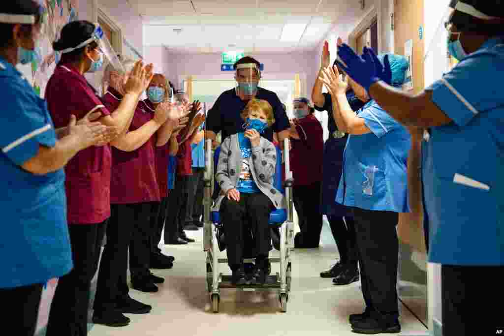 Margaret Keenan, 90, is applauded by staff as she returns to her ward after becoming the first patient in the UK to receive the Pfizer-BioNTech COVID-19 vaccine, at University Hospital, Coventry, England.