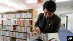 A ripped copy of Anne Frank's "Diary of a Young Girl" picture book is shown by Shinjuku City Library Director Kotaro Fujimaki at the library in Tokyo Friday, Feb. 21, 2014. 