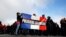 Polisi memegang bendera Perancis bertuliskan "Polisi yang Marah" dalam demonstrasi di depan Majelis Nasional di Paris (26/10). (AP/Christophe Ena)