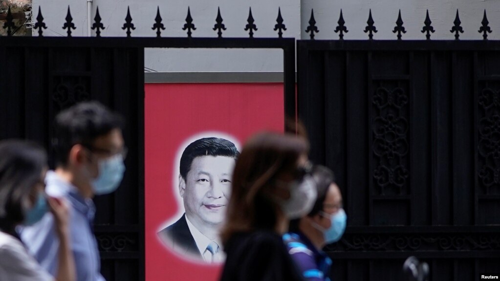 资料照：戴着口罩的上海市民走过内有一幅习近平画像的大门。（2020年5月22日）