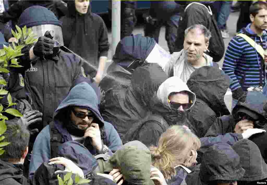 German policemen use pepper spray against left-wing protesters during May Day demonstrations in Rostock.
