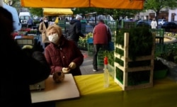 A woman shops as the farmers markets open in Prague, Czech Republic, April 20, 2020.