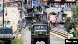 Kendaraan militer pasukan Filipina melakukan patroli melewati kawasan permukiman yang hancur akibat perang di Marawi, Filipina selatan Kamis (19/10).