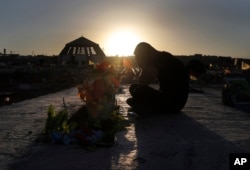 A Kurdish man mourns as he sits next to the grave of his friend who was killed while fighting against Islamic State militants in Raqqa, at a cemetery in Kobani, Syria, July 28, 2017.