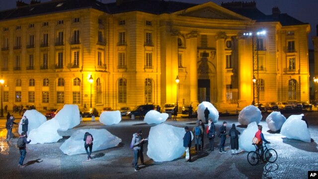 Visitantes caminan entre bloques de hielo parte de la escultura "Vigilia de hielo" del artista danés, Olafur Eliasson, en París.