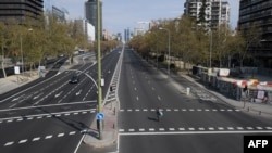 Jalan La Castellana avenue yang biasanya ramai dan macet di Madrid, Spanyol tampak sepi akibat lockdown oleh pemerintah, Minggu (15/3). 