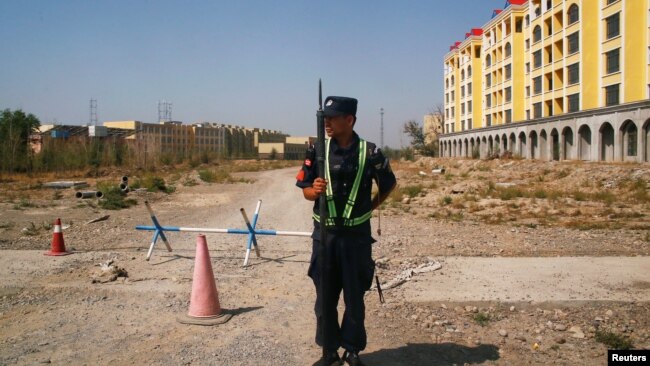 在新疆伊宁通往一个中国当局称作“职业训练中心”的再教育营的道路上,一名中国警察在站岗。(2018年9月4日)