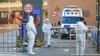 Workers in protective suits stand at an entrance to a university's residential area under lockdown following the coronavirus disease (COVID-19) outbreak in Xian, Shaanxi province, China, Dec. 20, 2021. (China Daily via Reuters)