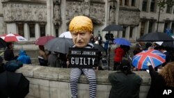 A person dressed as a caricature of British Prime Minister Boris Johnson in a prison uniform sits outside the Supreme Court in London, Sept. 24, 2019, after it made it's decision on the legality of Johnson's five-week suspension of Parliament.