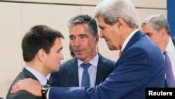 U.S. Secretary of State John Kerry, right, addresses Ukraine Foreign Minister Pavlo Klimkin, left, as NATO Secretary General Anders Fogh Rasmussen listens at a NATO meeting in Brussels June 25, 2014.