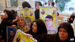 被以色列监禁的巴勒斯坦囚犯的家属2013年10月28日在加沙的红十字会办事处前示威，要求以色列释放他们的家人。