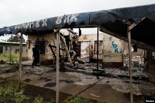 A Cameroonian elite Rapid Intervention Battalion (BIR) member patrols the abandoned village of Ekona near Buea in the anglophone southwest region, Oct. 4, 2018.