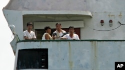 North Korean sailors look out from the deck of their cargo ship Chong Chon Gang in Sherman Bay near Colon City, Panama, Wednesday, Feb. 12, 2014
